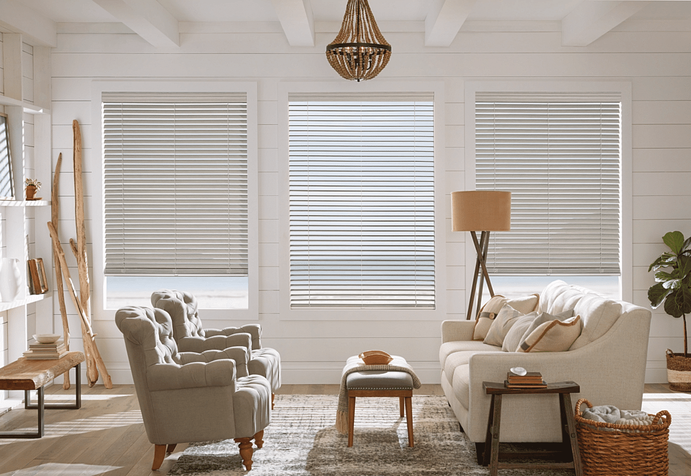 white-faux-wood-blinds-living-room-omaha Three large windows in a bright coastal living room featuring white custom faux wood blinds and shiplap walls.